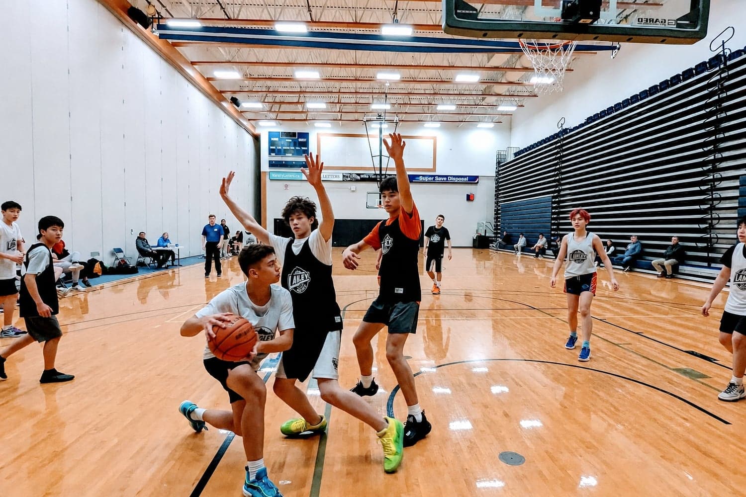 North Langley players in a live game — a young athlete drives past defenders to the basket